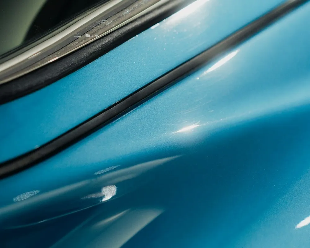Reflets de lumière ondulant sur une aile de carrosserie lustrée