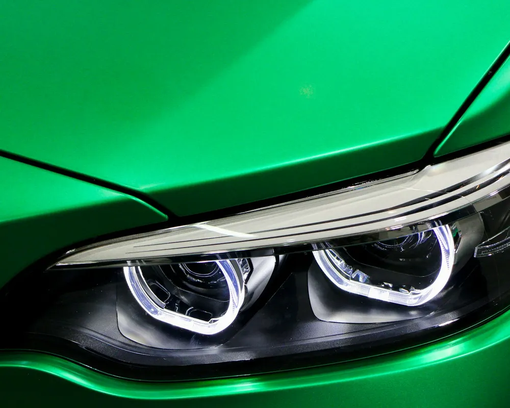 Gros plan sur la carrosserie peinte verte d'une automobile